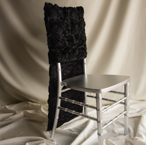 Black rosette chair cover on a silver colored Chiavari chair in front of a white back drop.
