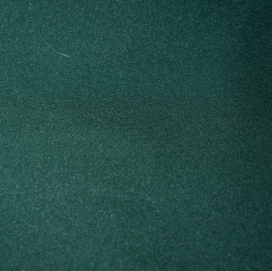 Close up of a forest green colored polyester tablecloth.