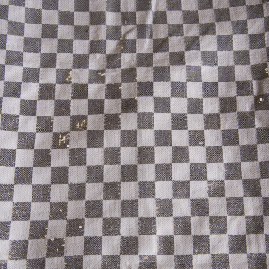 Close up of a silver checkered sequin tablecloth.