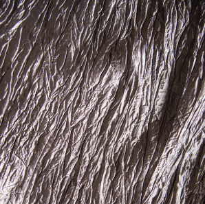 Close up of a silver colored crinkled accordion tablecloth.